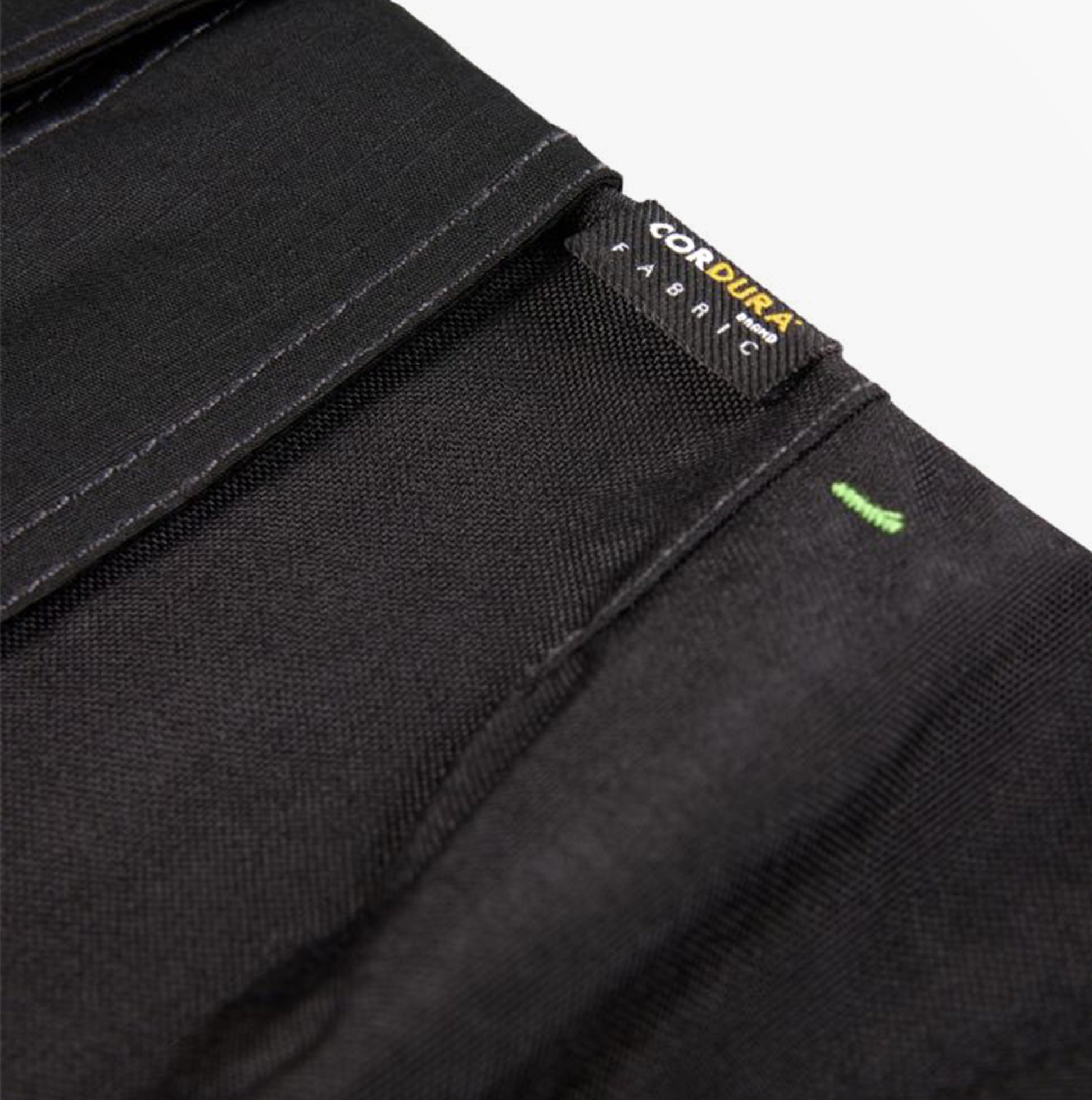 Detail view of Apache SUDBURY Mens Trousers Black showing Cordura fabric label and texture.