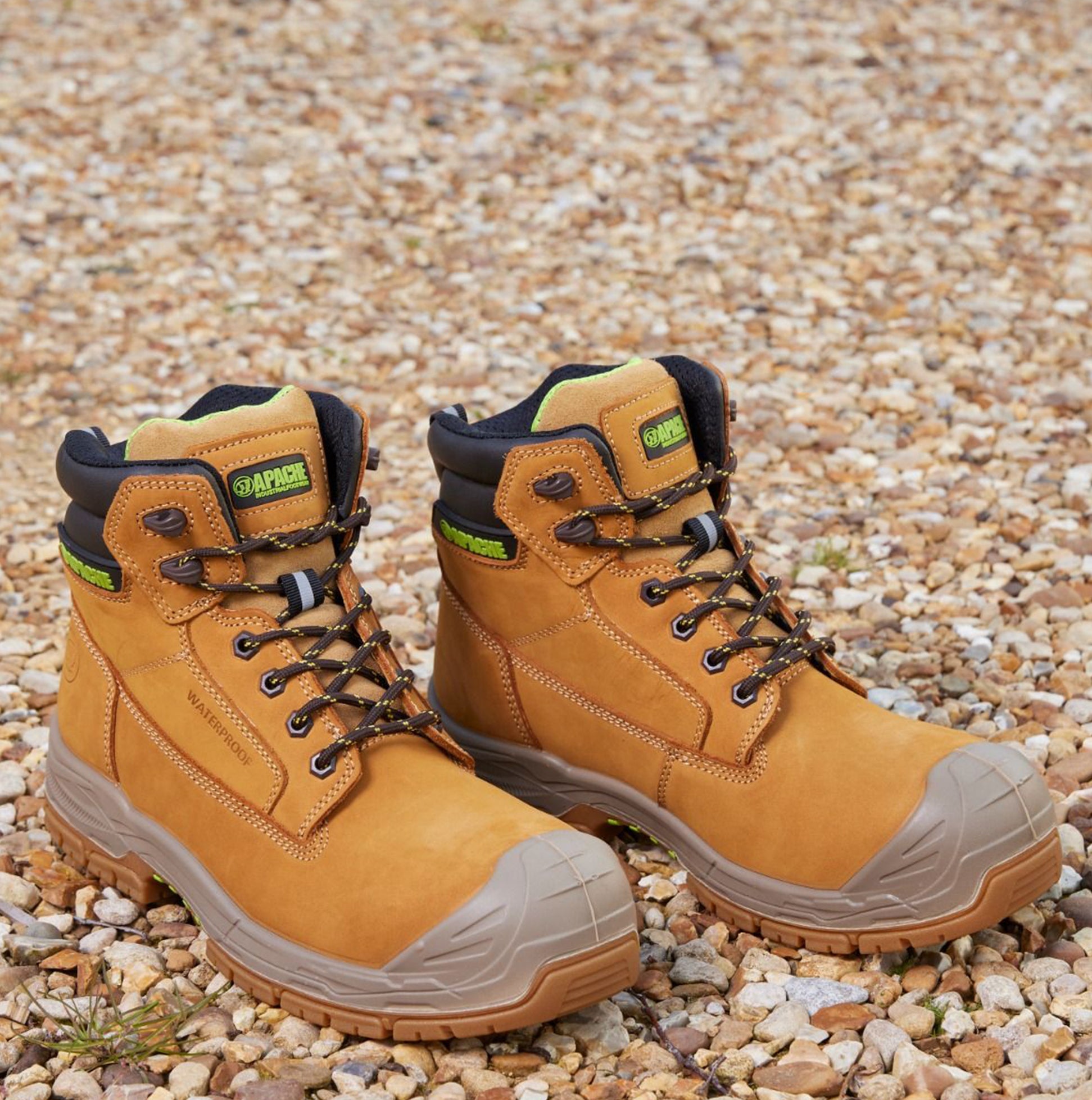 Apache THOMPSON Unisex Boots Wheat side view showing the light brown leather upper and rubber sole on a gravel surface.